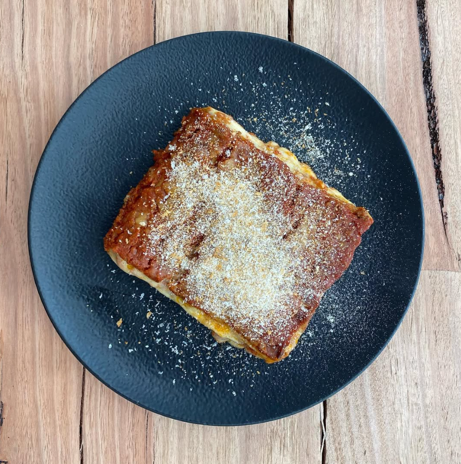 Fresh pastry slice on a black plate