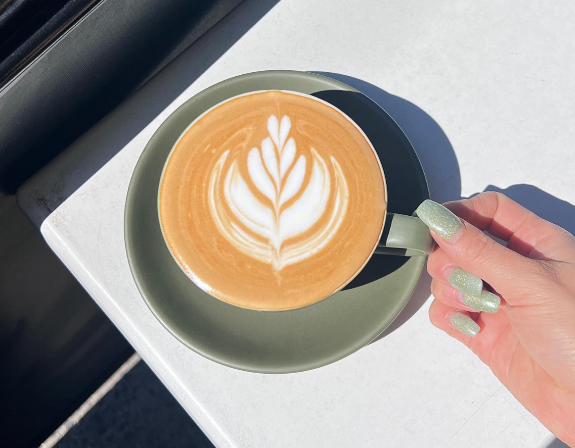 Latte with leaf art in the morning sun
